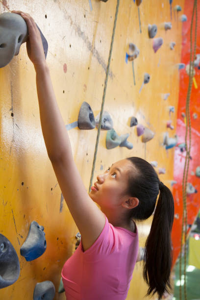 istock Chinese woman scaling rock wall 1083127226
