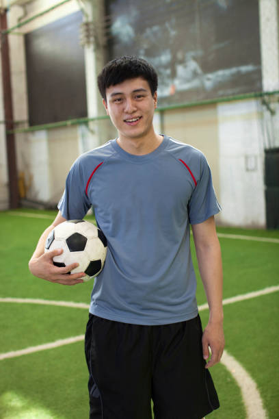 istock Chinese soccer player standing on pitch 1083127236