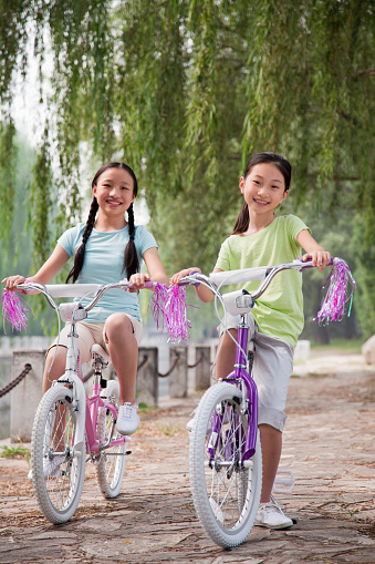 Chinese girls riding bicycles in park