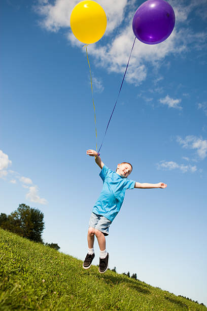 istock Carefree Young Boy Jumping with Balloons Outside 108312904