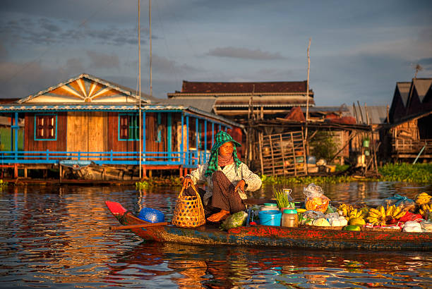 Boat in water in front of colorful Cambodian village  Cambodian market seller, Floating Village, Kampong Kleang, Siem Reap, Cambodia. Lots of detail, please look close up.. siem reap stock pictures, royalty-free photos & images