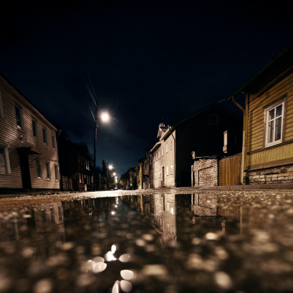 street with wooden houses in puddle reflection.