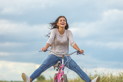The happy woman ride a bicycle outdoor