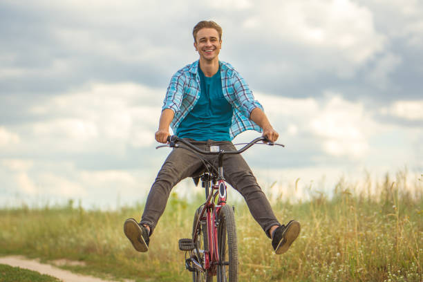 istock The happy man ride a bicycle in a field 1083133270