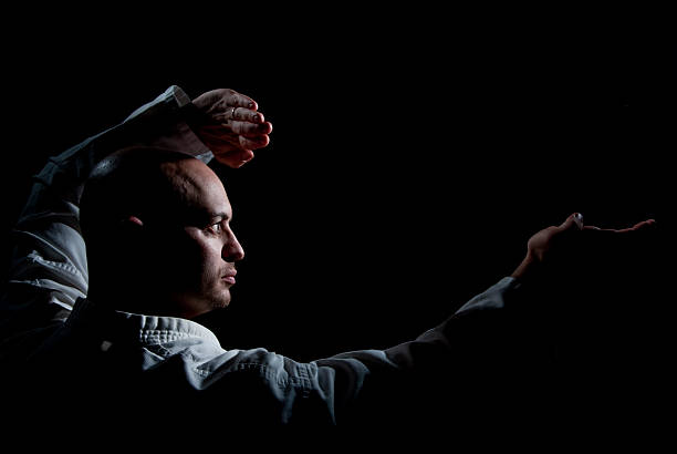 A man in a hood reaches out from the darkness. Robbery and Fraud