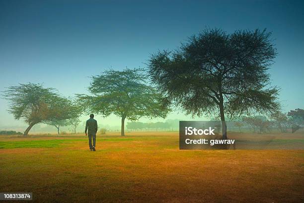 Mężczyzna Samotnie Spacery W Parku Na Foggy Rano - zdjęcia stockowe i więcej obrazów Wschód słońca - Wschód słońca, Odejście, Horyzont