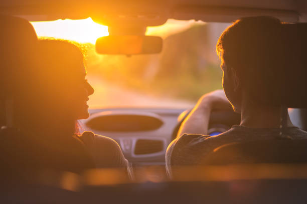 o par conduz um carro no fundo do por do sol - car driving inside of indoors - fotografias e filmes do acervo