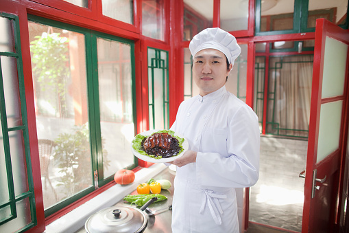 Chinese cook showing food in kitchen