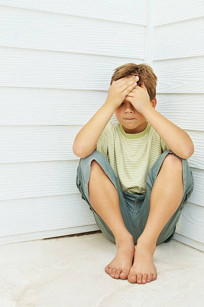 istock Unhappy boy sitting with head in hands 108314602