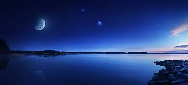 Photo of Rising moon over lake