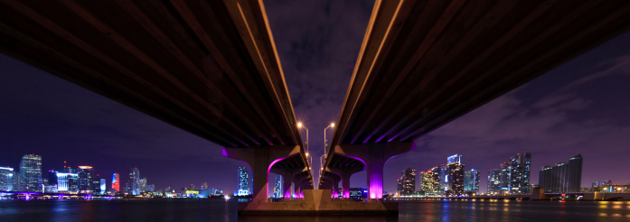 The MacArthur Causeway from below, going to Miami Beach, shoot at night with the city skyline and the Downtown - Brickell and Biscayne skyline in the background