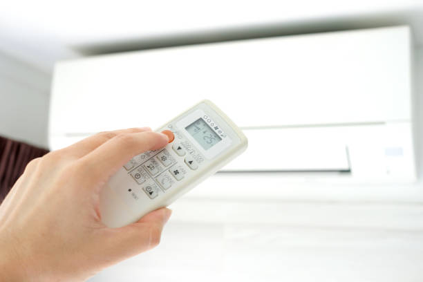 istock Man's hand using remote control open The air conditioner is cooled to 25 degrees Celsius in his bedroom. Health concepts and energy savings 1083148646