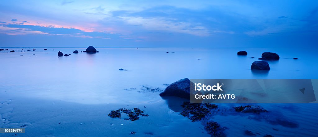 Ruhige blaue Meer mit riesigen Felsen bei Sonnenuntergang - Lizenzfrei Abenddämmerung Stock-Foto