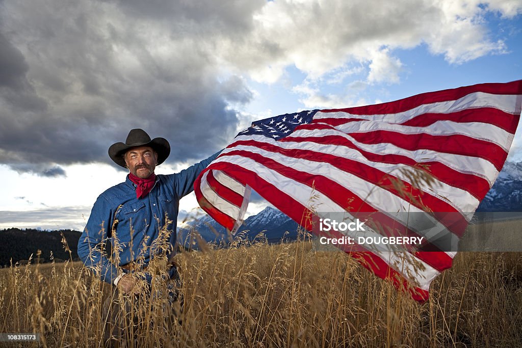 Cowboy con bandiera - Foto stock royalty-free di 40-44 anni