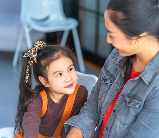 istock Teacher is reading story book to kindergarten students connection 1083154628