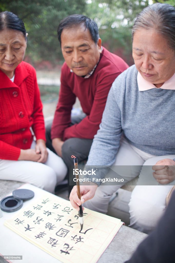 Chinesische Frau üben Kalligraphie im park - Lizenzfrei Alter Erwachsener Stock-Foto