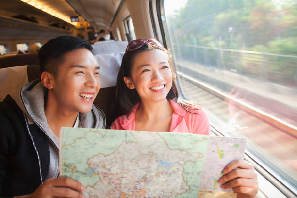 chinese paar reading kaart op trein - reizen in azië stockfoto's en -beelden