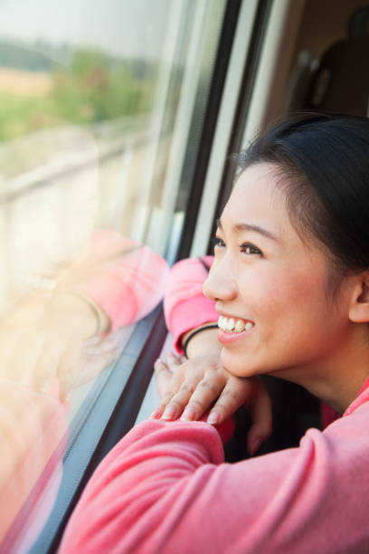 istock Chinese woman looking out train window 1083155018