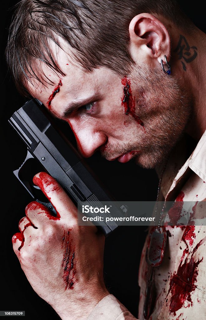 Bloody Soldier Holding Gun Soldier holding gun with intense stare. reminiscent of cinematic or video game imagery. Adult Stock Photo