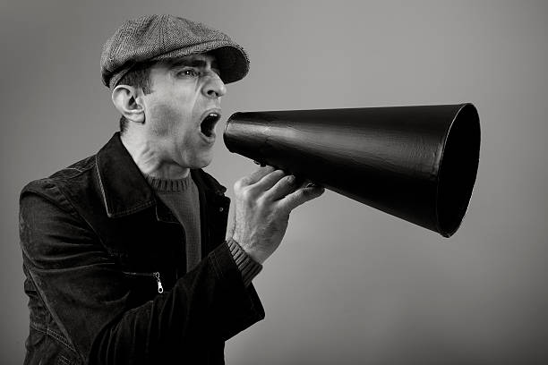 istock Adult Man Wearing Flat Cap Shouting On Old Fashioned Megaphone 108315930