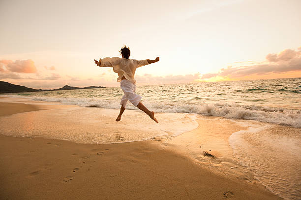 mujer en la playa - jumping freedom women beach fotografías e imágenes de stock