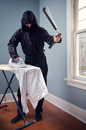 A ninja multi tasks at home, wielding his \