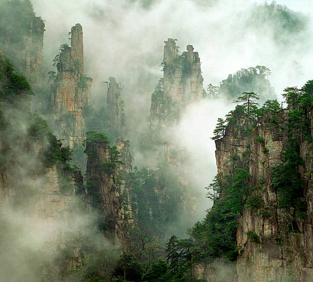 creekside view with a small bridge. Yangjiajie scenic area in china. Tall obelisk stone with deep valleys.