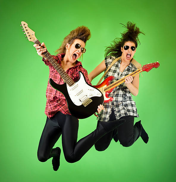 Young teenage couple having fun playing electric guitars together at home