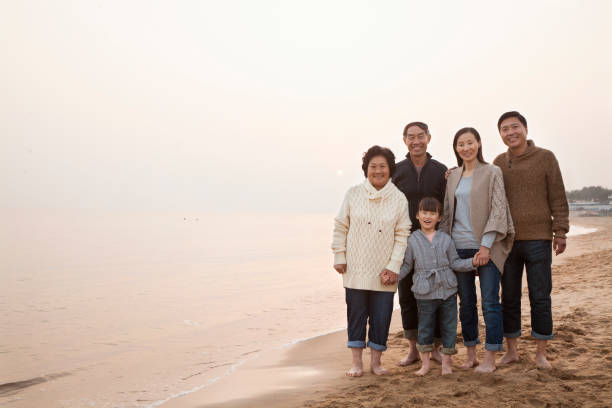istock Chinese family standing on beach 1083165028