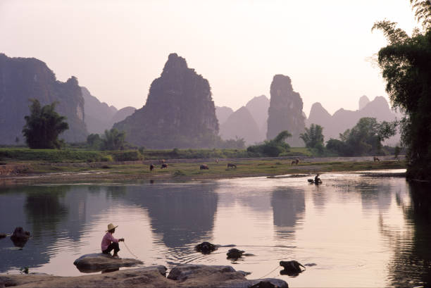 istock A cloudy sunset of Li River with man with pet 108316784