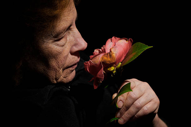 istock Nostalgic Elderly Senior Smell a Wilted Flower. Color Image 108316919