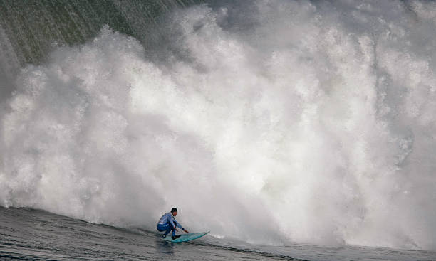Surfing a Huge Wave  mavericks california stock pictures, royalty-free photos & images