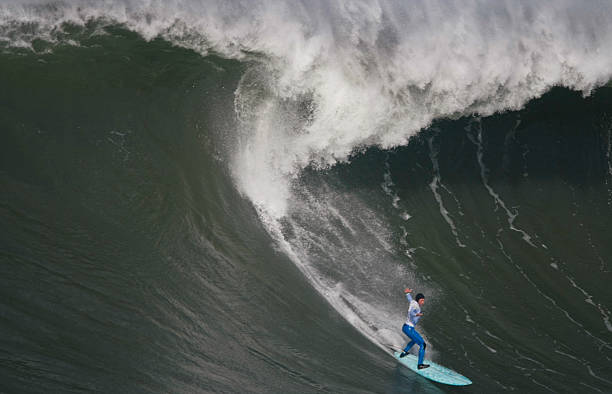 Surfing the curl of a huge wave  mavericks california stock pictures, royalty-free photos & images