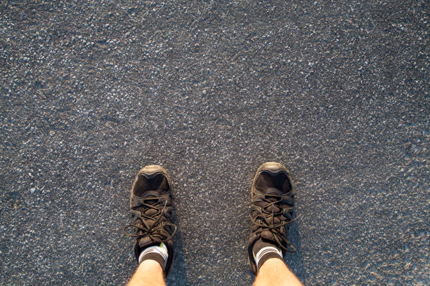 istock man in hiking shoes standing on black asphalt 1083200634