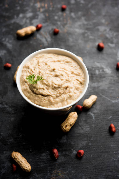 istock Healthy Peanut chutney made using Groundnut / Shengdana or mungfali. served in a small bowl with raw whole. Selective focus 1083216300