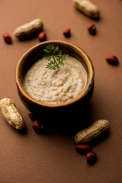 healthy peanut chutney made using groundnut / shengdana or mungfali. served in a small bowl with raw whole. selective focus - chutney imagens e fotografias de stock