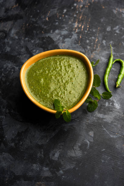 Healthy Green Mint Chutney Made with Coriander, pudina And Spices. isolated moody background. selective focus Healthy Green Mint Chutney Made with Coriander, pudina And Spices. isolated moody background. selective focus chutney stock pictures, royalty-free photos & images