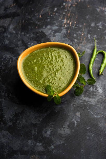 healthy green mint chutney made with coriander, pudina and spices. isolated moody background. selective focus - chutney imagens e fotografias de stock