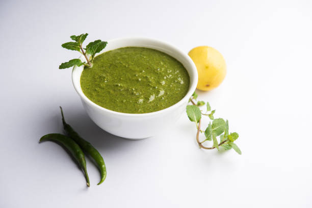 Healthy Green Mint Chutney Made with Coriander, pudina And Spices. isolated moody background. selective focus stock photo