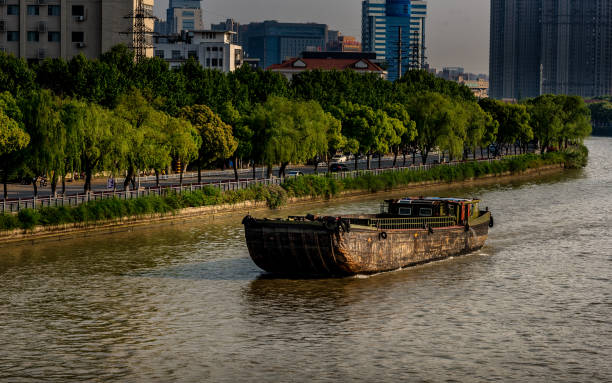 The Grand Canal of China A boat crossing the canal in Wuxi, Jiangsu Province. grand canal china stock pictures, royalty-free photos & images