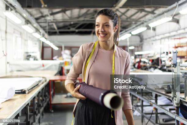 Smiling Young Woman In A Fashion Factory Stock Photo - Download Image Now - Occupation, Working, Textile Industry