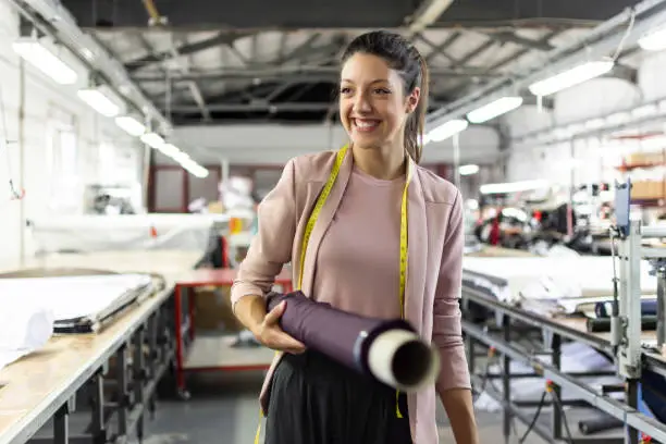 Photo of Smiling young woman in a fashion factory