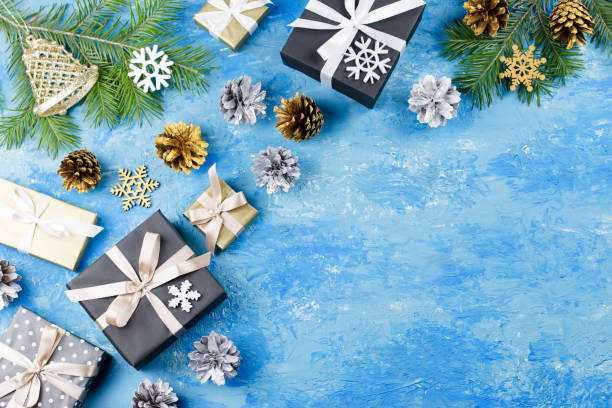 istock Blue Christmas frame with fir branches, black giftboxes, silver and golden decorations 1083256050