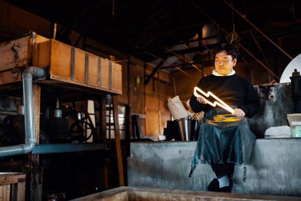 istock Handmade paper artist holding an illuminated lightning bolt shaped neon light 1083261656
