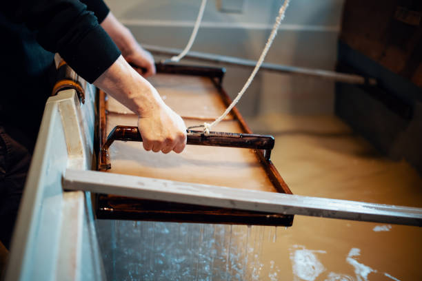istock Mid adult Japanese man making paper using traditional methods 1083261830
