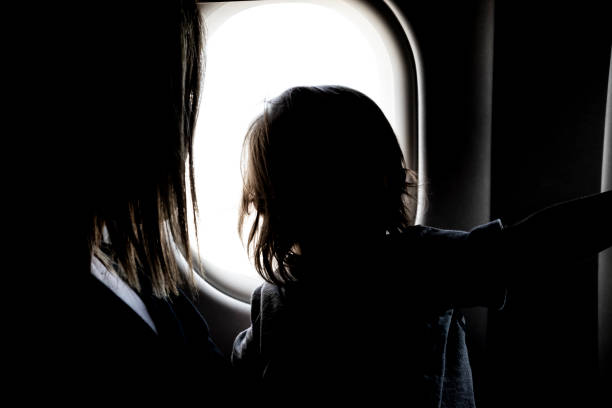 istock Silhouette head view from an airplane window 1083261860