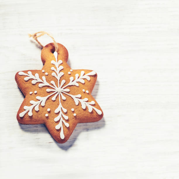 Gingerbread cookies over wooden background with copy space. Macro shot with selective focus. Retro photo style.