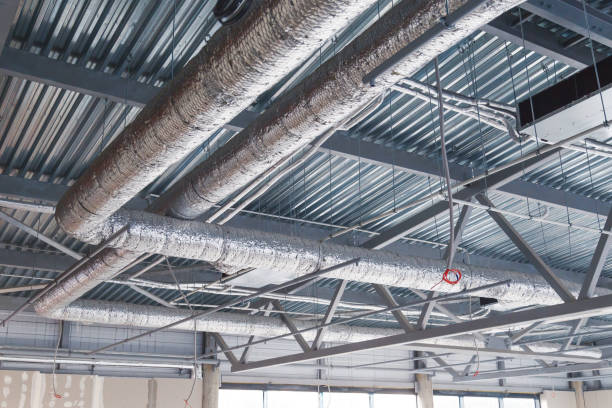 HVAC. Ventilation pipes in silver insulation material hanging from the ceiling inside new building. stock photo