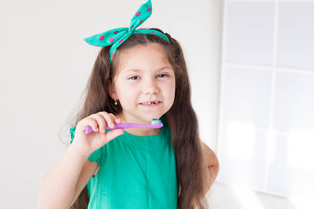 istock little girl brushing his teeth with a toothbrush dent 1083278050