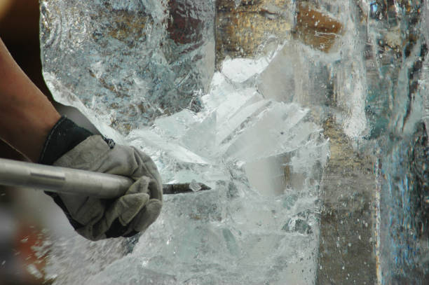 An ice-cutter carving a statue from a block of ice.